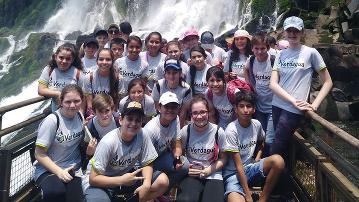 Grupo de estudiantes con remeras de Verdagua frente a las Cataratas del Iguazú