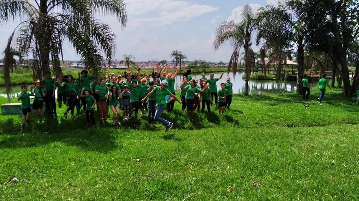 Grupo de estudiantes festejando en un parque junto al agua